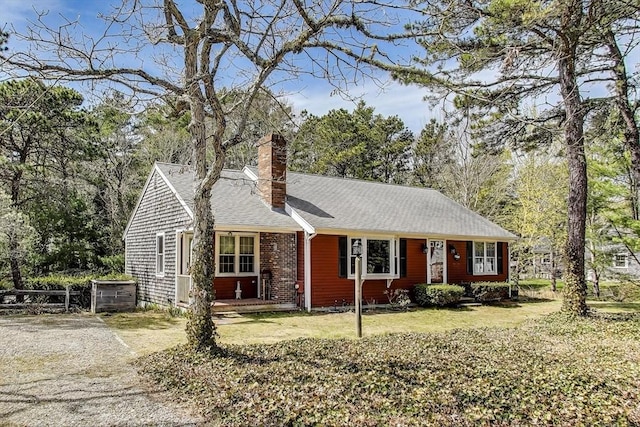 49 Lady Slipper Dr, Dennis, MA 02638 - single story home with roof with shingles, fence, a chimney, and a front lawn