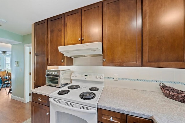 23 Rufus Jones Ln Unit 23, Easton, MA 02356 - kitchen with under cabinet range hood, white electric range oven, light countertops, decorative backsplash, and light wood-style floors