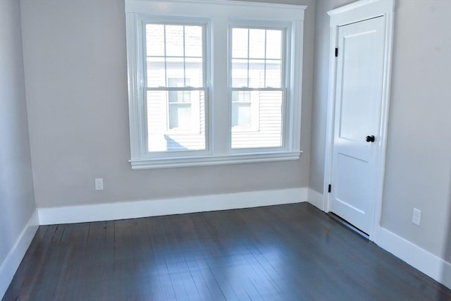 unfurnished room featuring dark wood finished floors and baseboards