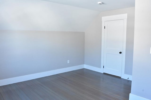 bonus room with vaulted ceiling, dark wood-type flooring, and baseboards