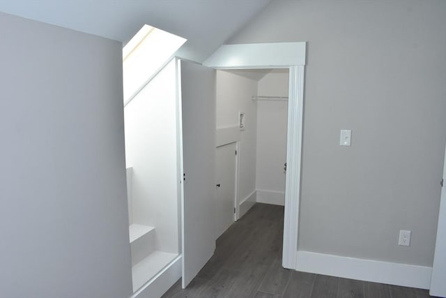 interior space with vaulted ceiling, baseboards, and wood finished floors