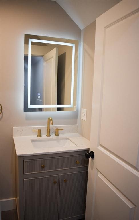 bathroom with lofted ceiling and vanity