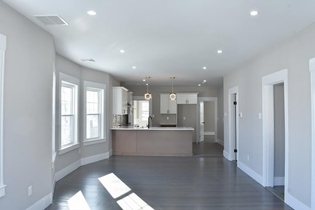 kitchen with recessed lighting, a peninsula, dark wood-type flooring, visible vents, and light countertops