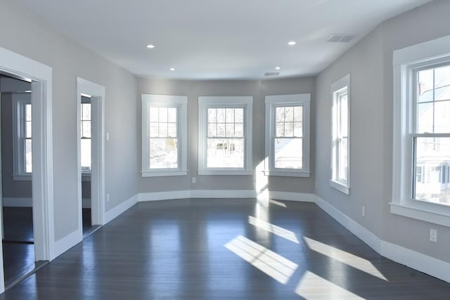 empty room with recessed lighting, visible vents, dark wood finished floors, and baseboards