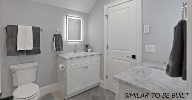 10 Webber Ave Unit 4D, Bedford, MA 01730 - bathroom featuring vanity, baseboards, toilet, marble look tile flooring, and vaulted ceiling