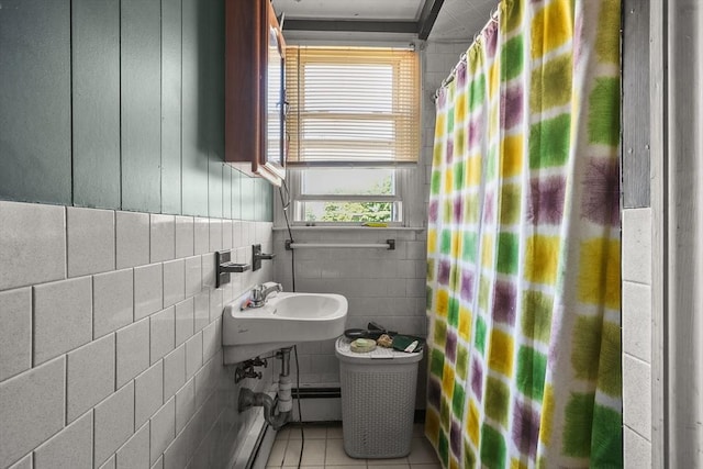 bathroom with tile walls, tile patterned flooring, plenty of natural light, and sink