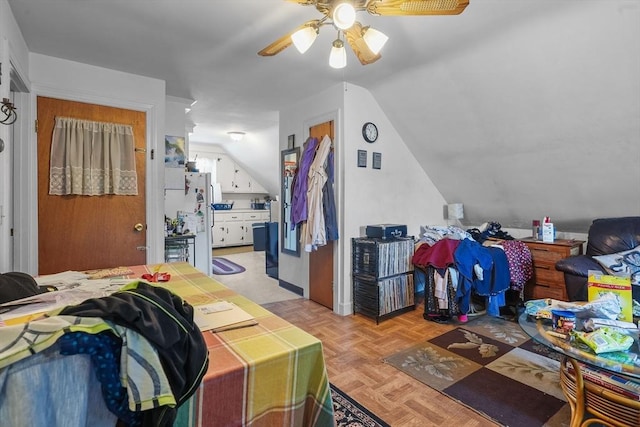 bedroom with ceiling fan, light parquet floors, white fridge, and lofted ceiling