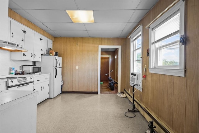 kitchen featuring white cabinets, a drop ceiling, white appliances, and wooden walls