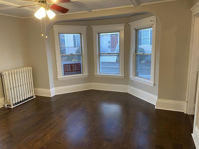 unfurnished room with radiator heating unit, dark hardwood / wood-style flooring, ceiling fan, and crown molding