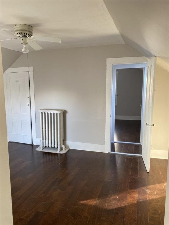 additional living space with ceiling fan, dark wood-type flooring, and vaulted ceiling