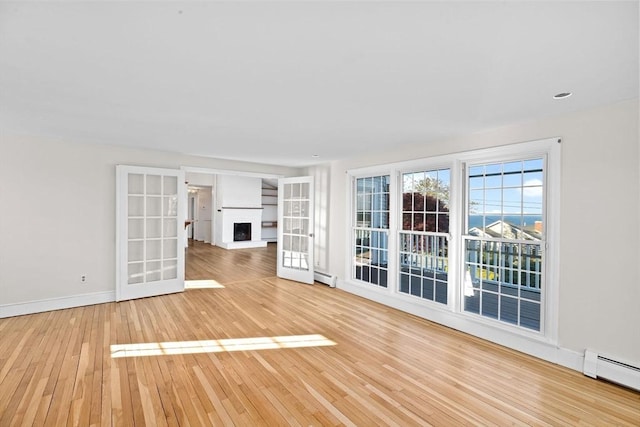 51 Shore Dr, Plymouth, MA 02360 - unfurnished living room with a baseboard heating unit, hardwood / wood-style flooring, baseboards, and a fireplace with raised hearth