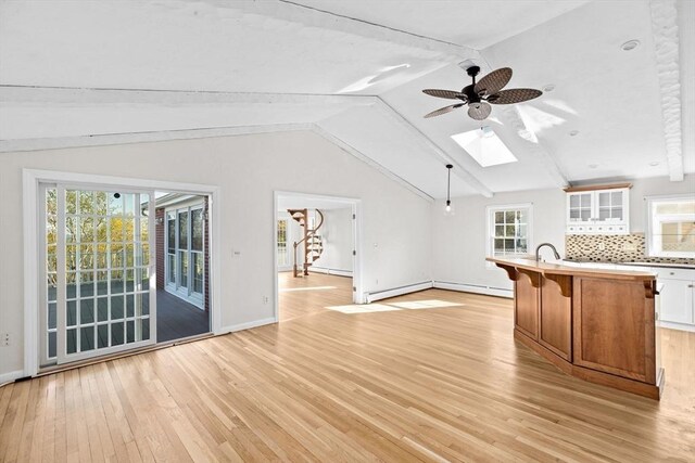 51 Shore Dr, Plymouth, MA 02360 - unfurnished living room with light wood-type flooring, a skylight, a ceiling fan, baseboards, and baseboard heating