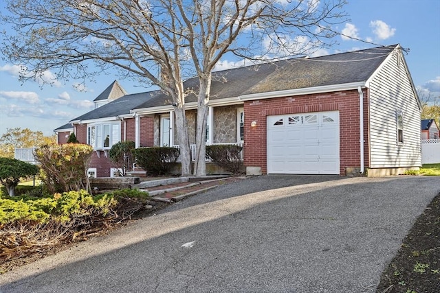 51 Shore Dr, Plymouth, MA 02360 - view of front facade with a garage, brick siding, and driveway