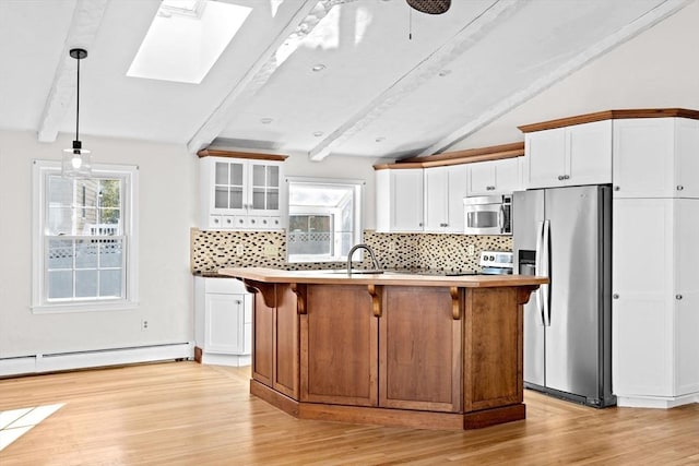 51 Shore Dr, Plymouth, MA 02360 - kitchen featuring appliances with stainless steel finishes, a skylight, decorative backsplash, white cabinets, and light wood finished floors