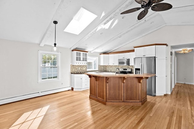 51 Shore Dr, Plymouth, MA 02360 - kitchen featuring appliances with stainless steel finishes, a skylight, a baseboard heating unit, decorative backsplash, and white cabinets