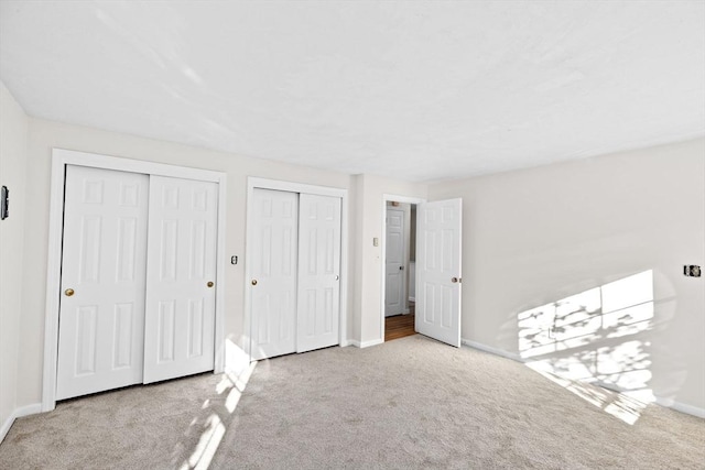 51 Shore Dr, Plymouth, MA 02360 - unfurnished bedroom featuring carpet, two closets, and baseboards