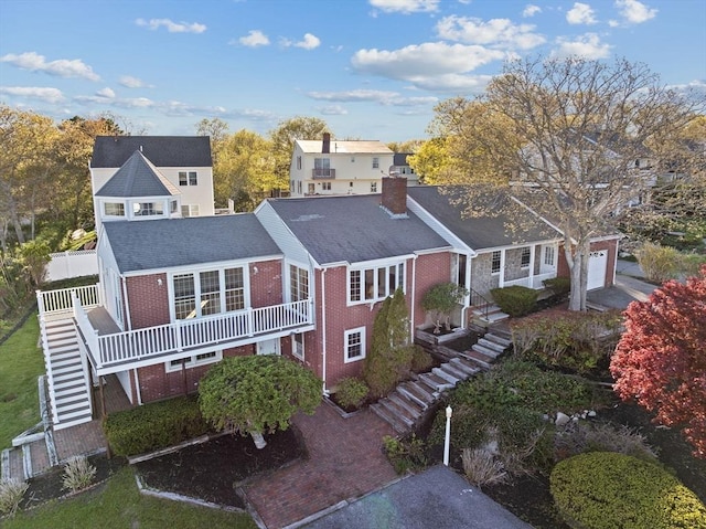 51 Shore Dr, Plymouth, MA 02360 - view of front of property with stairway, brick siding, a chimney, an attached garage, and fence