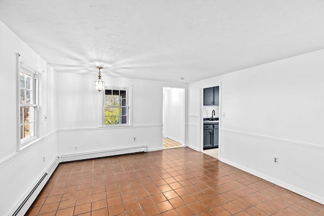 51 Shore Dr, Plymouth, MA 02360 - tiled spare room with baseboard heating, a sink, baseboards, a textured ceiling, and a chandelier