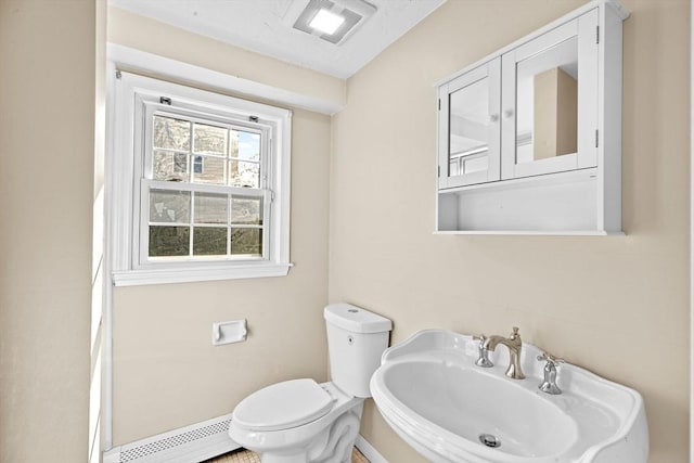 51 Shore Dr, Plymouth, MA 02360 - half bath with a baseboard heating unit, a sink, toilet, and baseboards