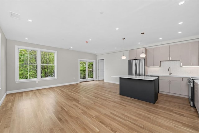 42 Waverly Unit 1, Boston, MA 02135 - kitchen featuring appliances with stainless steel finishes, a sink, a center island, light countertops, and backsplash