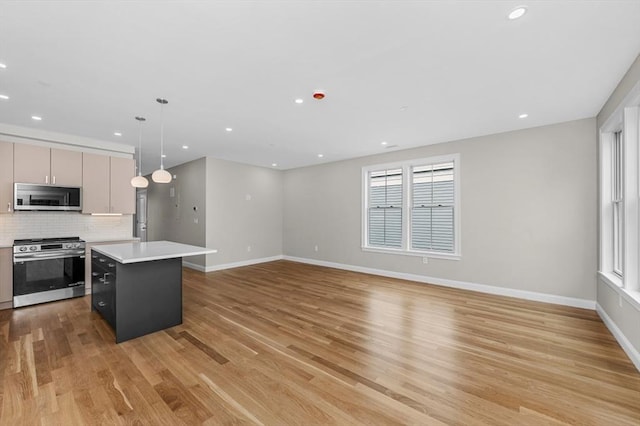 42 Waverly Unit 1, Boston, MA 02135 - kitchen with appliances with stainless steel finishes, light countertops, light wood-style floors, a kitchen island, and baseboards