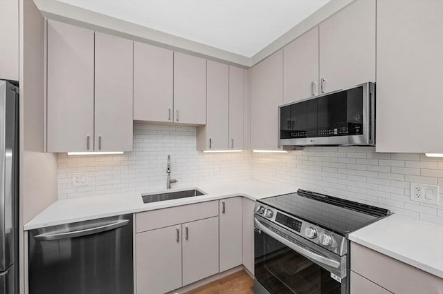 42 Waverly Unit 1, Boston, MA 02135 - kitchen with stainless steel appliances, a sink, light countertops, light wood-style floors, and backsplash