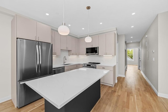 42 Waverly Unit 1, Boston, MA 02135 - kitchen featuring appliances with stainless steel finishes, a sink, decorative backsplash, light wood finished floors, and a center island