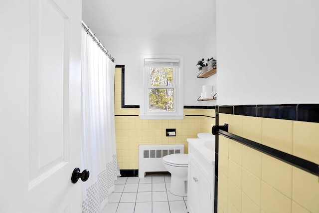 110 Walnut St, Canton, MA 02021 - bathroom with radiator, tile patterned floors, tile walls, toilet, and wainscoting