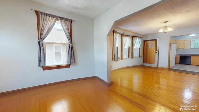 25 Garrison St, Fairhaven, MA 02719 - spare room with a chandelier, a textured ceiling, plenty of natural light, and wood finished floors