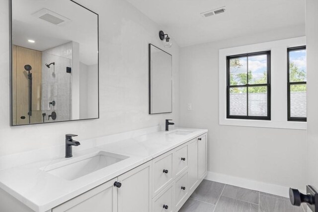 bathroom featuring tiled shower and vanity