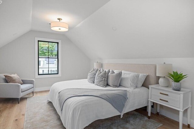 bedroom featuring lofted ceiling and light hardwood / wood-style flooring