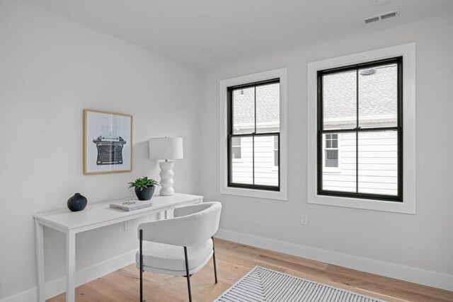 office space featuring built in desk and light hardwood / wood-style floors