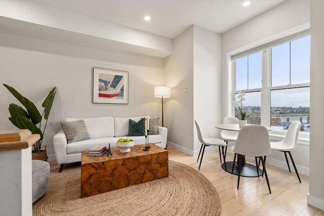 living room featuring baseboards, light wood finished floors, and recessed lighting