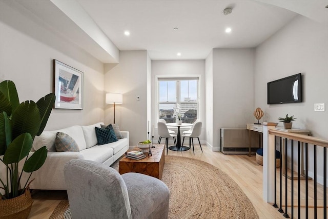 living room with light wood-type flooring, recessed lighting, and baseboards