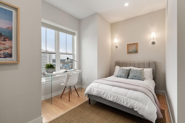 bedroom with wood finished floors, baseboards, an office area, and recessed lighting