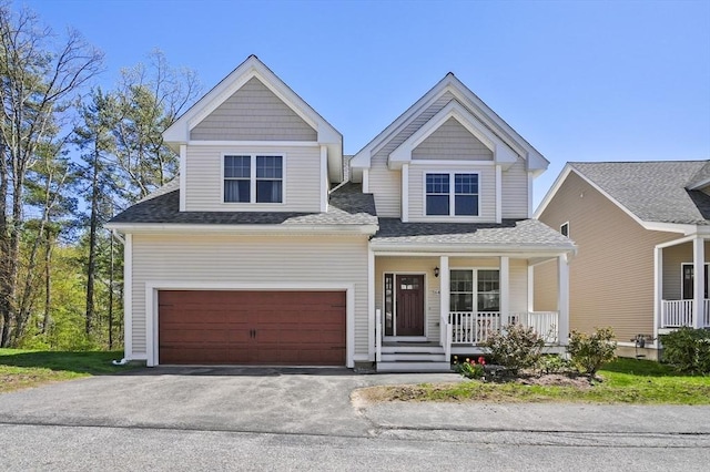 view of front of house with roof with shingles, covered porch, a garage, and aphalt driveway