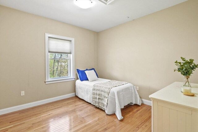 bedroom with light wood-type flooring and baseboards