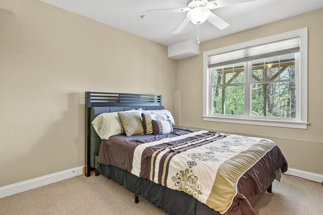 carpeted bedroom featuring baseboards and ceiling fan