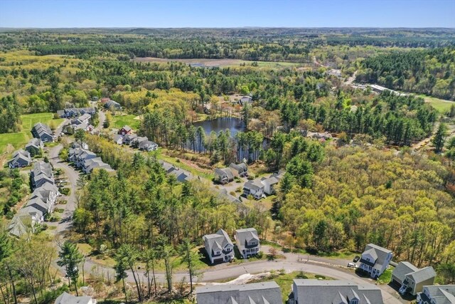 birds eye view of property featuring a forest view, a water view, and a residential view