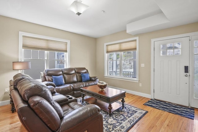 living area featuring light wood-style floors and baseboards