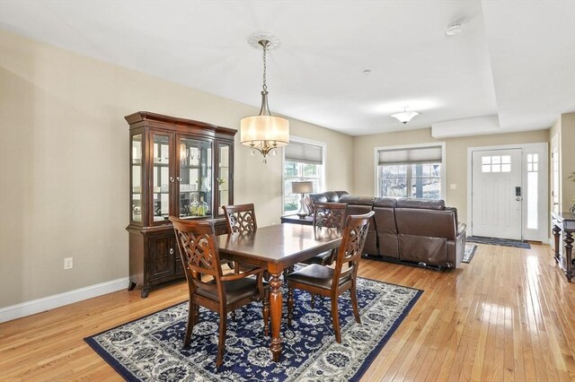 dining area featuring baseboards, a notable chandelier, and light wood-style flooring