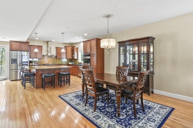 dining room featuring light wood-style floors, recessed lighting, baseboards, and a notable chandelier