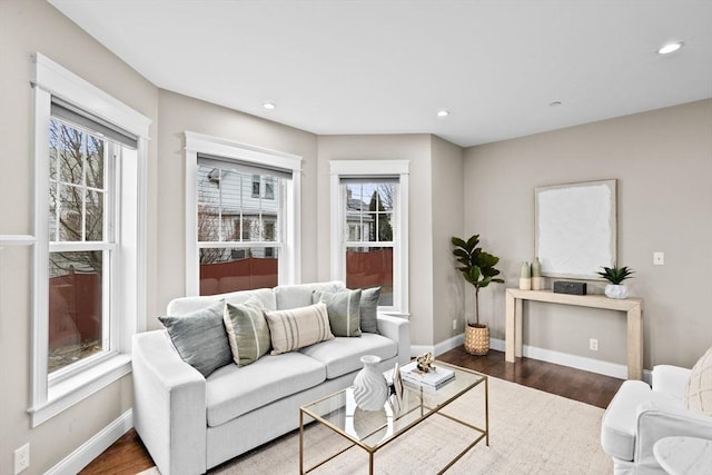 living room with dark wood-type flooring and a healthy amount of sunlight