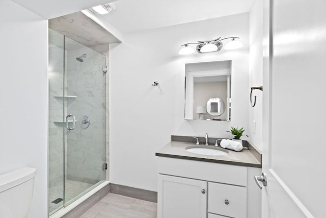 bathroom featuring vanity, toilet, and a shower with door