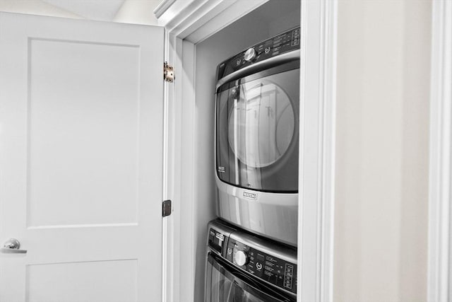 clothes washing area with stacked washer / dryer