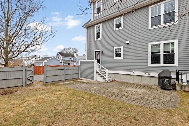 rear view of property with a yard and a patio