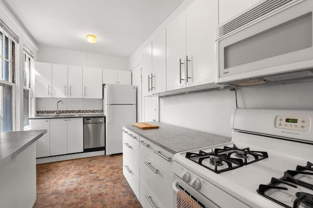 32 Sidlaw Rd Unit 14, Boston, MA 02135 - kitchen with white appliances, decorative backsplash, white cabinetry, and dark stone finish floors