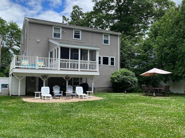 back of property featuring a yard, a patio area, and a sunroom