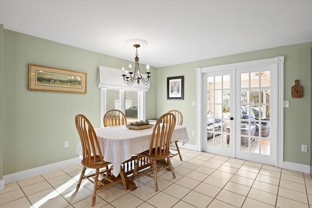 dining area with a healthy amount of sunlight, light tile patterned floors, french doors, and a notable chandelier