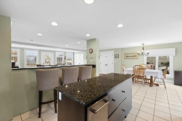 99 Ashburton Ave, Marshfield, MA 02050 - kitchen featuring light tile patterned flooring, a chandelier, a kitchen island, dark stone countertops, and recessed lighting